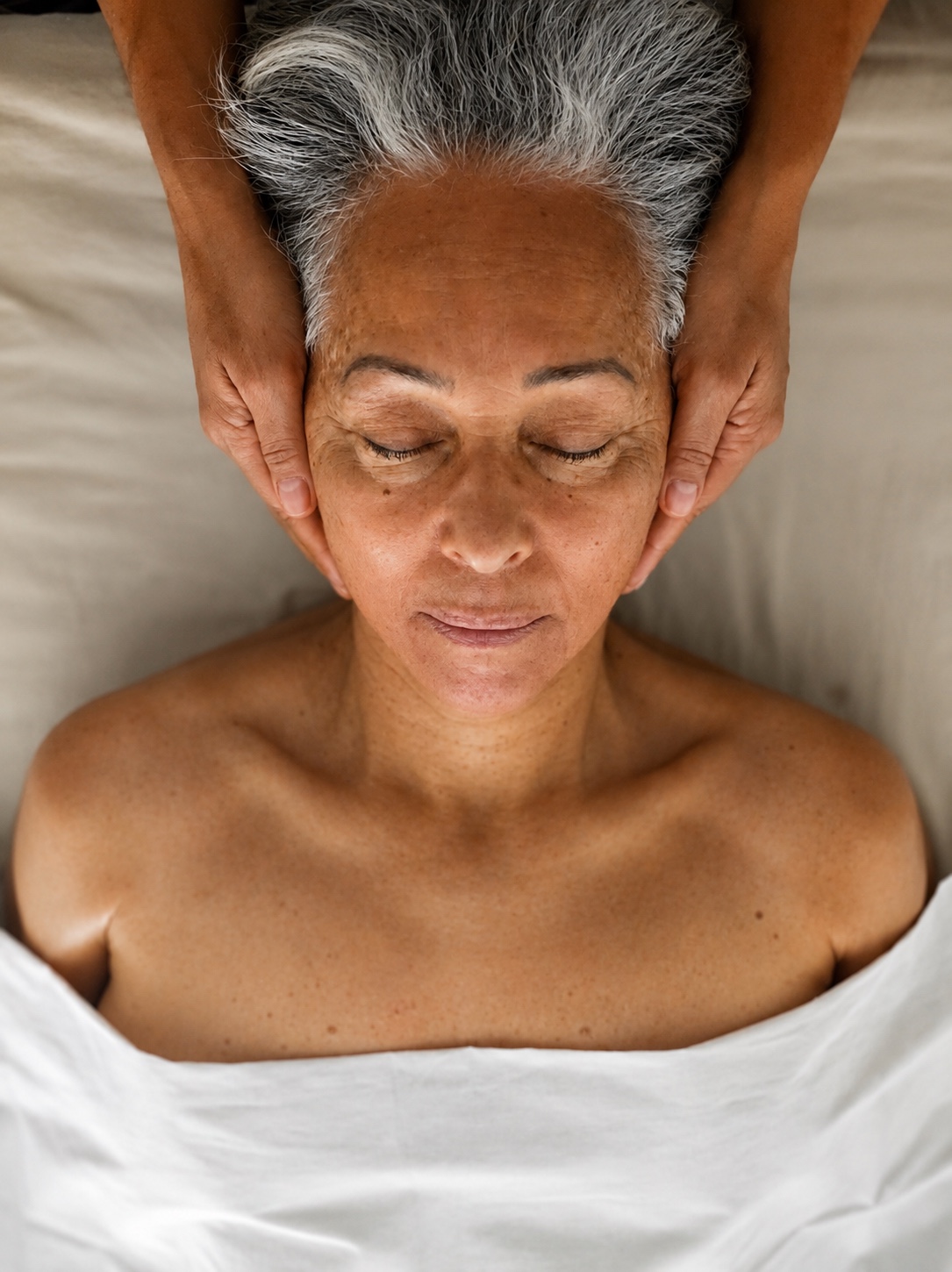 Mulher recebendo toque terapêutico na região da cabeça